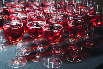 Alcohol setting on catering banquet table, row line of orange red coloured aperitif alcohol cocktails on party, negroni, spritz and others on bar counter, selection of liquor beverages on event
