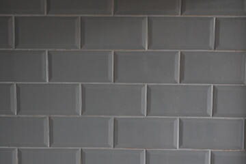 A gray tile wall with a pattern of squares