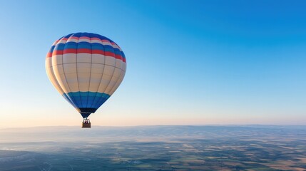 Obraz premium colorful hot air balloon floats serenely under clear blue sky with ample copy space above for text