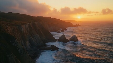 Dramatic sunset over rugged coastline with crashing waves and cliffs.