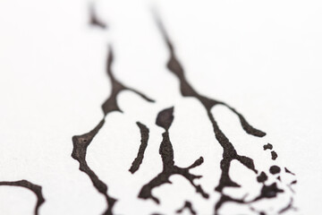 Extreme close up of black acrylic paint texture on paper. Selective focus.