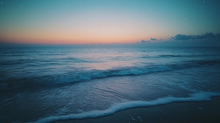 Serene ocean waves gently lapping the shore at dawn under a twilight sky.