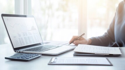 neatly organized workspace features tidy desk with open laptop showcasing financial graphs calculator and pen next