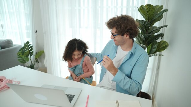 Funny caucasian dad and american kid doing funny face while put pencil between lip and nose. Cute family study about writing engineering prompt together and generating AI at laptop on table. Pedagogy.