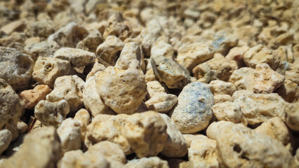 low angle close-up of decorative landscape rock for garden or erosion control. classic neutral tones backdrop of small screened pebbles with texture.