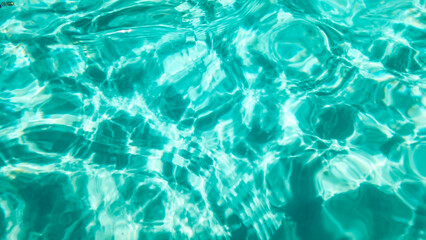 close-up abstract view of swimming pool water and light refraction on a sunny day with beautiful blue green and aquamarine tones. holiday vacation summer background.