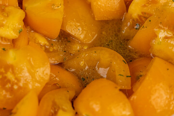 ripe orange tomatoes with spices cut into pieces of different sizes