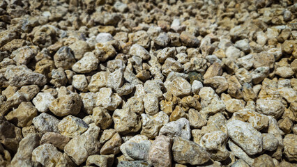 low angle close-up of decorative landscape rock for garden or erosion control. classic neutral tones backdrop of small screened pebbles with texture.