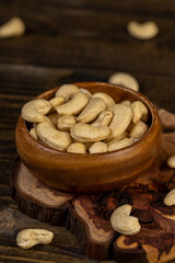 large cashew nuts are scattered on a larch board