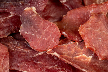 dried dried meat from meat tenderloin with spices and salt on black slate