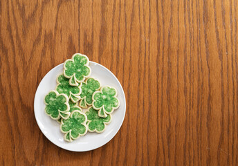 Green Shamrock Sugar Cookies On White Plate On Wood Table