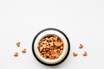 Bowl of biscuits for pets - food in a shape of heart, top view