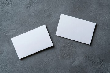 Two blank business cards on a textured grey background, perfect for branding, corporate identity, and design mockups. Ideal for marketing, advertising, and professional networking