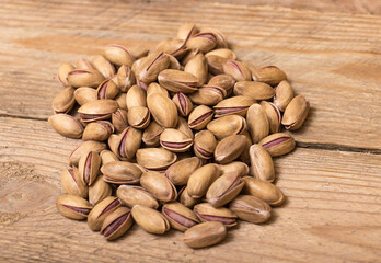 Pistachio nuts on a wooden trencher, natural and healthy snack concept	
