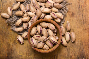 Pistachio nuts on a wooden trencher, natural and healthy snack concept