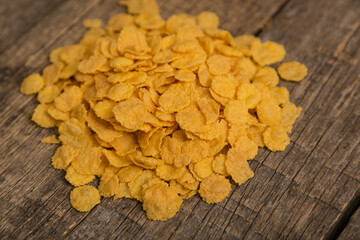 Cereal flakes on a wooden background. Sugary cereal on a old wooden background