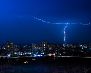 Nighttime Cityscape with Dramatic Lightning Illuminating the Sky