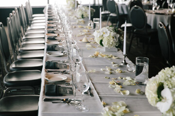 Elegant wedding reception table setting with floral decorations and fine dining arrangement in a well-lit venue