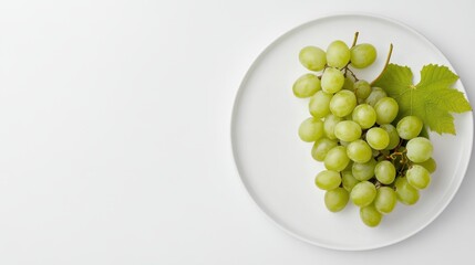 A bunch of fresh green grapes arranged on a white plate, on a white isolated background