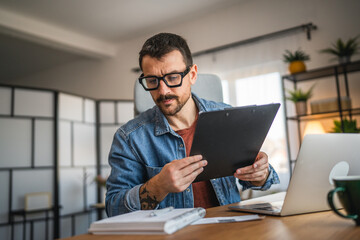 Fototapeta premium focused concentrated man work from home office and use clipboard