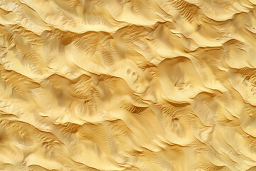 Golden sand dunes create stunning rippled patterns with organic shapes, conveying nature's beauty and tranquility. This aerial view highlights the textures and colors of a pristine desert marvel under