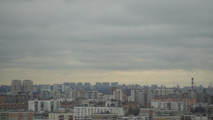 Moody city panorama shrouded in clouds. Diffused light creates mysterious atmosphere, highlighting architectural silhouettes. Perfect for urban ambiance, travel and cityscape projects