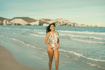 Young woman enjoying summer vacations walking on the beach in Spain