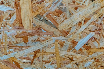 Natural wood shavings create a textured surface in a workshop setting during daylight hours