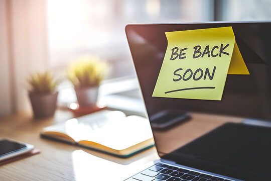 Laptop with "Be Back Soon" Sticky Note and Desk Accessories
