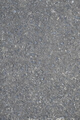 A grey and black pavement with a lot of gravel