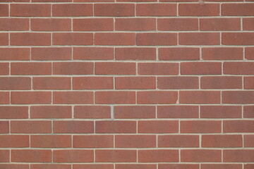 A brick wall with a red brick color