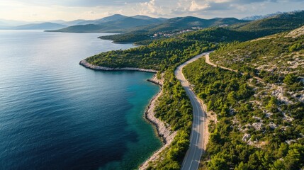 Obraz premium Aerial View of a Serene Coastal Road Cutting Through the Lush Macchia Landscape of Dalmatia, Croatia - A Beautiful Travel Destination