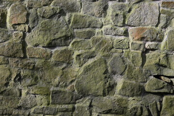 A wall made of stone with moss growing on it