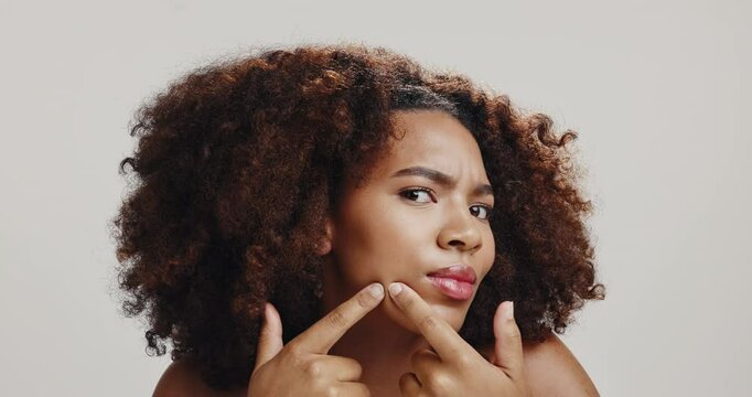 Face, black woman and skincare for acne, checking and skin breakout on white studio background. Portrait, African model and person with cosmetics, blemish and spa treatment for natural beauty