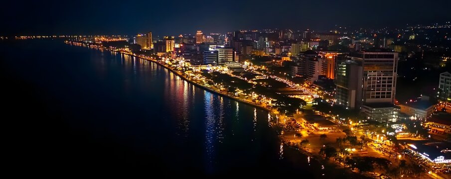 Manila, Philippines &ndash; An aerial view of Manila at night, showing the bustling city lights, Roxas Boulevard, and reflections on Manila Bay