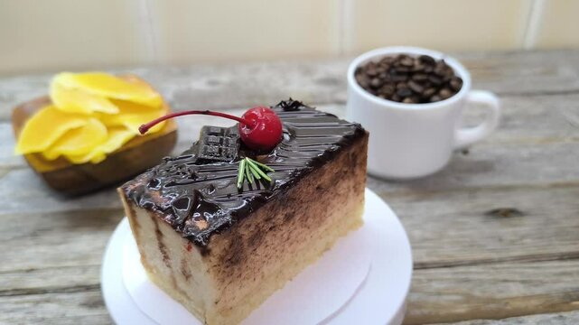 Chocolate cake with cherries lies on a white plate