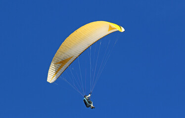 Paraglider flying in a blue sky	