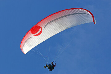 Paraglider flying in a blue sky	