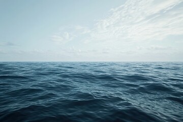 Fototapeta premium Wide view of a calm ocean under a clear sky with gentle waves