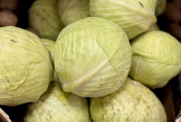 Heads of white cabbage, offered for sale in grocery stores around vegetables - products rich in calcium, vitamins, inexpensive healthy natural products. Close-up