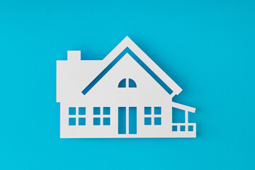 House shaped paper cutout on light blue background. Minimal concept. Flat lay style. Top view banner.