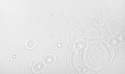 Background with clear white water. Blurred background, transparent water surface with splashes and wave texture with ripples. Top view, copy location, text location.