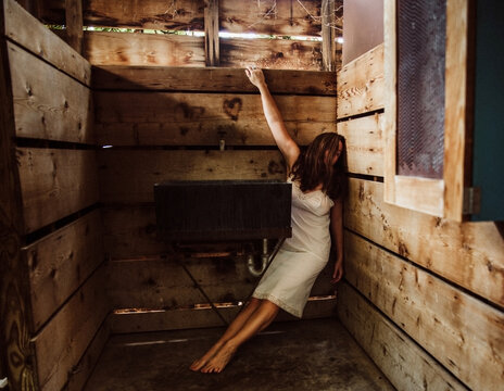 Woman hanging from wooden wall