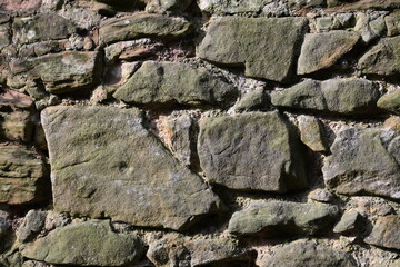 A wall made of stone with moss growing on it