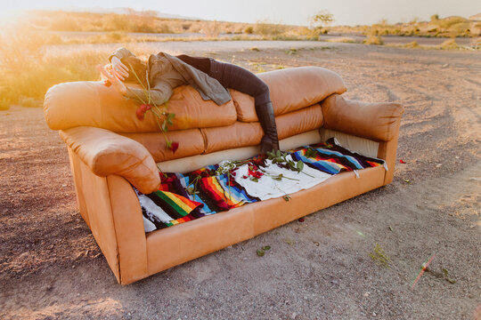 Woman Lying on back of couch in desert