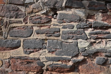 A wall made of stone with a few holes in it