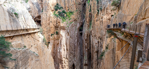 Hikers experience the breathtaking El Caminito del Rey walkway in M&aacute;laga, Spain, on a sunny day.