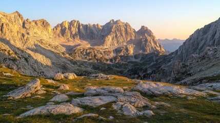 Fototapeta premium Majestic mountain range at sunset, rocky foreground, alpine meadow.