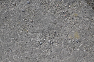 A grey and rocky surface with a few small rocks scattered around