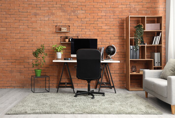 Interior of office with workplace, shelf unit and sofa